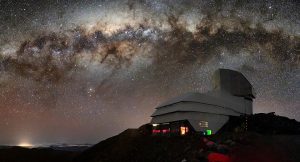 This image captures not only Vera C. Rubin Observatory, a Program of NSF’s NOIRLab, but one of the celestial specimens Rubin Observatory will observe when it comes online: the Milky Way. The bright halo of gas and stars on the left side of the image highlights the very center of the Milky Way galaxy. The dark path that cuts through this center is known as the Great Rift, because it gives the appearance that the Milky Way has been split in half, right through its center and along its radial arms. In fact, the Great Rift is caused by a shroud of dust, which blocks and scatters visible light. This dust makes the Great Rift a difficult space to observe. Fortunately, Rubin is being built to conduct the Legacy Survey of Space and Time (LSST). This survey will observe the entire visible southern sky every few nights over the course of a decade, capturing about 1000 images of the sky every night and giving us a new view of our evolving Universe. The LSST is set to probe four areas of science, one of which is mapping the Milky Way to answer questions about its structure and formation. Once Rubin Observatory comes online in 2024, scientists will be able to access the data taken every night of operation. Rubin Observatory is a joint initiative of the National Science Foundation and the Department of Energy (DOE). Once completed, Rubin will be operated jointly by NSF’s NOIRLab and DOE's SLAC National Accelerator Laboratory to carry out the Legacy Survey of Space and Time.